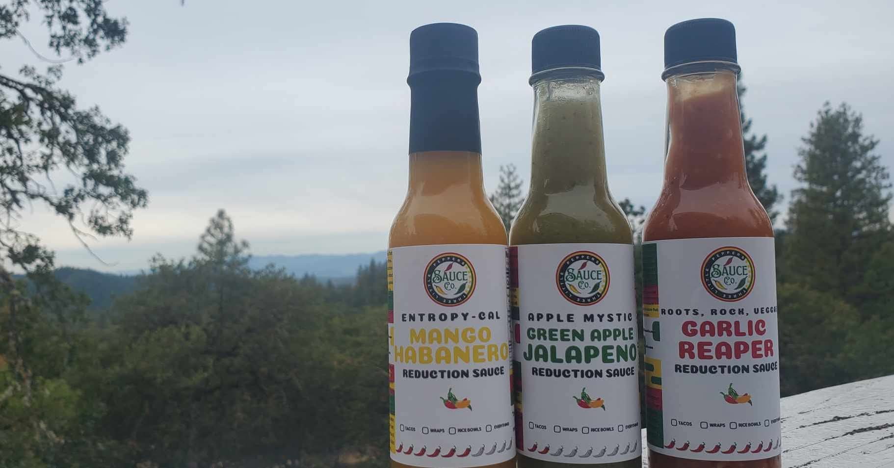 Four Three Little Peppers sauces surrounded by a Southern Oregon harvest