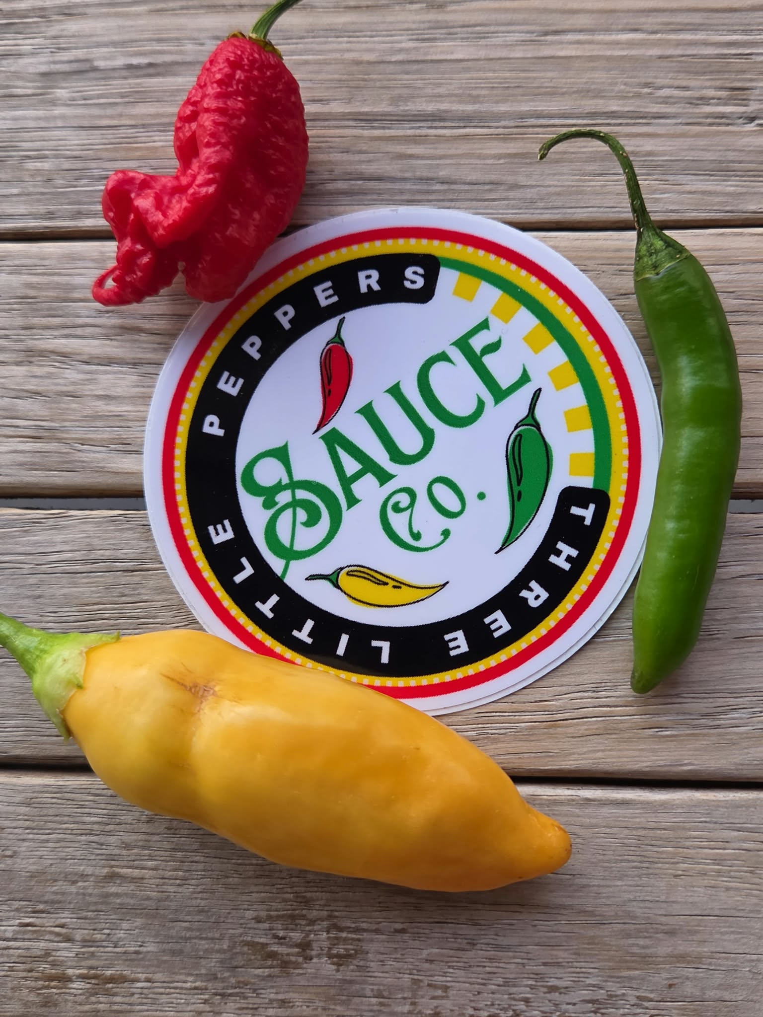 Three Little Peppers Sauce Co. logo surrounded by colorful peppers from the Martin family garden